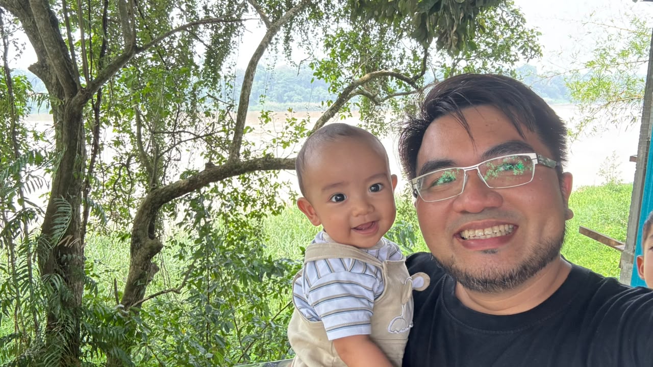 Syazwan off duty, outdoors by the river with his son